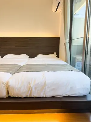 a bedroom with a large bed with a wooden headboard at ISSHUKU NOMA\u6c60\u888bII 103 - Quad Room in Tokyo