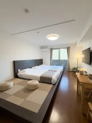 a bedroom with a large bed with a large rug at ISSHUKU NOMA\u6c60\u888bII 103 - Quad Room in Tokyo