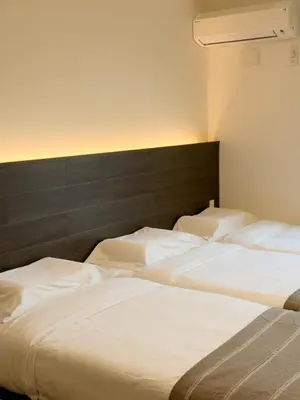 two beds in a room with white sheets at ISSHUKU NOMA\u6c60\u888bII 103 - Quad Room in Tokyo