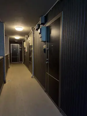 a corridor of a hallway with dark wood walls and a long aisle at ISSHUKU NOMA\u6c60\u888bII 105 - Quad Room in Tokyo