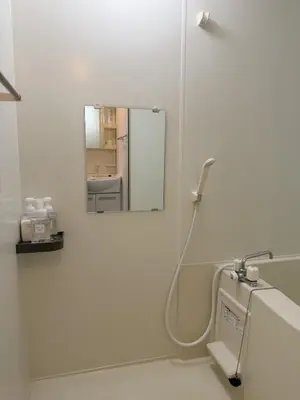 a white bathroom with a mirror and a sink at ISSHUKU NOMA\u6c60\u888bII 301 - Spacious Room for 5 Guests in Tokyo