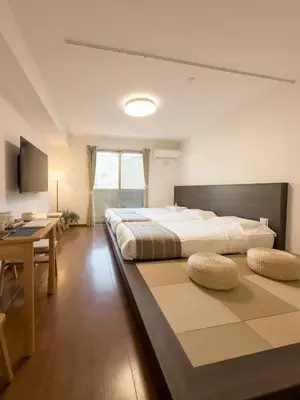 a large bedroom with a large bed and a table at ISSHUKU NOMA\u6c60\u888bII 302 - Quad Room in Tokyo