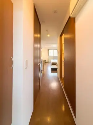 a hallway leading to a room with a door and a bed at ISSHUKU NOMA\u6c60\u888bII 302 - Quad Room in Tokyo