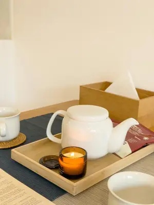 a tea set with a candle on a wooden tray at ISSHUKU NOMA\u6c60\u888bII 302 - Quad Room in Tokyo