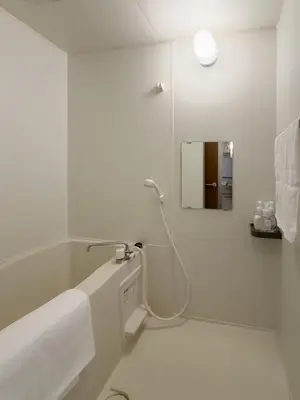 a white bathroom with a shower and a mirror at ISSHUKU NOMA\u6c60\u888bII 302 - Quad Room in Tokyo