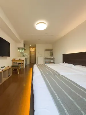 a bedroom with a large white bed and a desk at ISSHUKU NOMA\u6c60\u888bII 303 - Quad Room in Tokyo