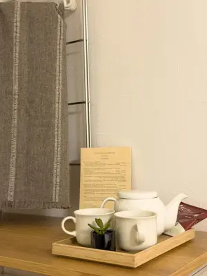 a tray with cups and a tea set on a table at ISSHUKU NOMA\u6c60\u888bII 303 - Quad Room in Tokyo