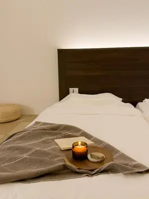 a candle sitting on top of a bed with a blanket at ISSHUKU NOMA\u6c60\u888bII 305 - Quad Room in Tokyo