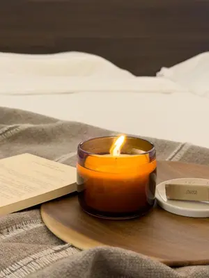 a candle on a wooden tray next to a book at ISSHUKU NOMA\u6c60\u888bII 305 - Quad Room in Tokyo