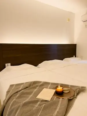 a bed with a tray with a candle on it at ISSHUKU NOMA\u6c60\u888bII 305 - Quad Room in Tokyo