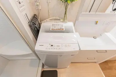 a washing machine is sitting in a room at 80m to Aoto Station Elevator Access 35 Min Direct to Haneda Airport Direct Train to Narita Airport Easy Access to Ginza Asakusa Disney Skytree Convenience Store and Pharmacy Downstairs in Tokyo