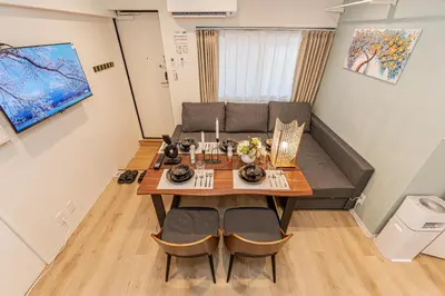 a living room with a table and a couch at 80m to Aoto Station Elevator Access 35 Min Direct to Haneda Airport Direct Train to Narita Airport Easy Access to Ginza Asakusa Disney Skytree Convenience Store and Pharmacy Downstairs in Tokyo