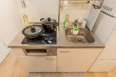 a small kitchen with a stove and a sink at 80m to Aoto Station Elevator Access 35 Min Direct to Haneda Airport Direct Train to Narita Airport Easy Access to Ginza Asakusa Disney Skytree Convenience Store and Pharmacy Downstairs in Tokyo