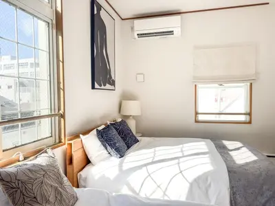 a bedroom with two beds and a window at New Open! Shinjuku 5 bedrooms 3 bathrooms Large Villa 2000 sq ft, kids play room, max 16ppl, 4min train to Shinjuku - Magnolia Hotel Shinjuku in Tokyo