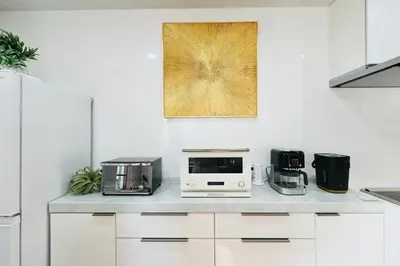 a kitchen with a counter with appliances on it at New Open! Shinjuku 5 bedrooms 3 bathrooms Large Villa 2000 sq ft, kids play room, max 16ppl, 4min train to Shinjuku - Magnolia Hotel Shinjuku in Tokyo