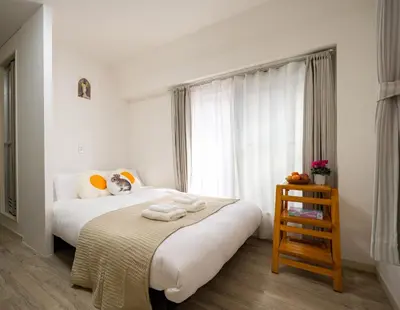 a bedroom with a bed with white sheets and a window at \u5466\u5466\u9e7f\u9e23\u6c11\u5bbf301\u4e0a\u91ce\u9644\u8fd1\u5165\u8c37\u4e0a\u91ce\u516c\u56ed\u6b65\u884c\u5708 \u65e5\u6bd4\u8c37\u7ebf jr\u7ebf \u53cc\u7ebf\u53ef\u5229\u7528 in Tokyo
