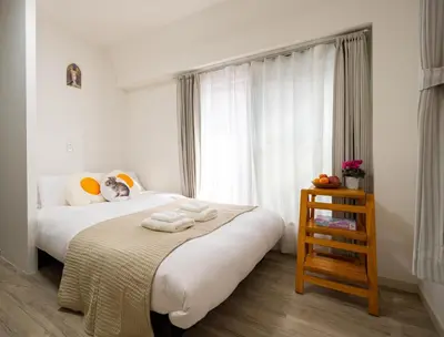 a bedroom with a bed with white sheets and a window at \u5466\u5466\u9e7f\u9e23\u6c11\u5bbf301\u4e0a\u91ce\u9644\u8fd1\u5165\u8c37\u4e0a\u91ce\u516c\u56ed\u6b65\u884c\u5708 \u65e5\u6bd4\u8c37\u7ebf jr\u7ebf \u53cc\u7ebf\u53ef\u5229\u7528 in Tokyo