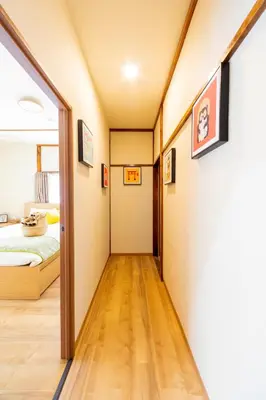 a corridor of a room with a bed and a mirror at Sky land House Asakusa in Tokyo