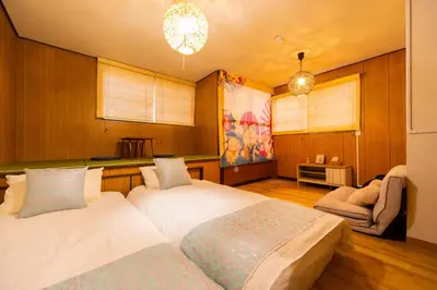 a bedroom with two beds and a chair at Sky land House Asakusa in Tokyo