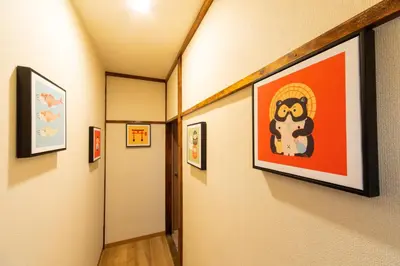 a hallway with framed art on the walls at Sky land House Asakusa in Tokyo