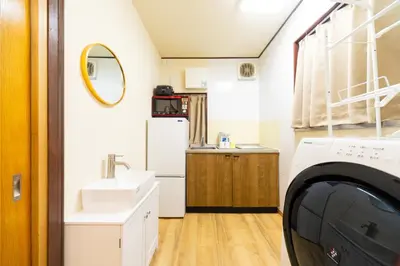 a laundry room with a sink and a washing machine at Sky land House Asakusa in Tokyo
