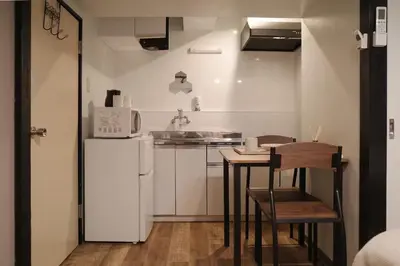 a small kitchen with a table and a refrigerator at \u6cca\u5bb6\u6771\u795eHakuya toshin in Wada