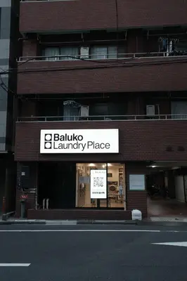 a store front of a brick building with a sign at \u6cca\u5bb6\u6771\u795eHakuya toshin in Wada