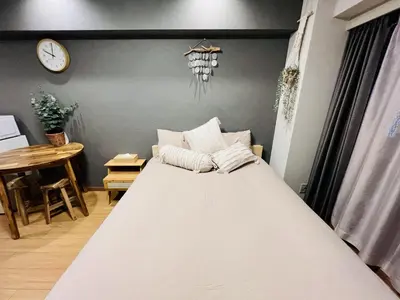 a large bed in a room with a clock on the wall at TokyoShinjuk Station800meterskabukicho2minutes224 in Tokyo