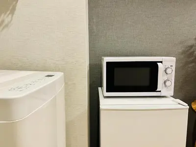 a microwave sitting on top of a white refrigerator at TokyoShinjuk Station800meterskabukicho2minutes224 in Tokyo