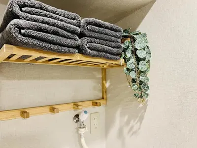 a wooden shelf with towels and a plant on it at TokyoShinjuk Station800meterskabukicho2minutes224 in Tokyo