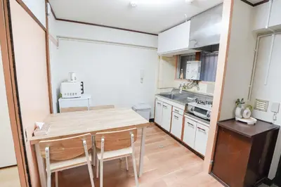 a small kitchen with a wooden table and chairs at 102Room,Free Parking Only 1 Stop from Ikebukuro Entire 33m on 1st Floor 2 Bedrooms for up to 6 Guests 3Minute Walk to Don Quijote in Tokyo