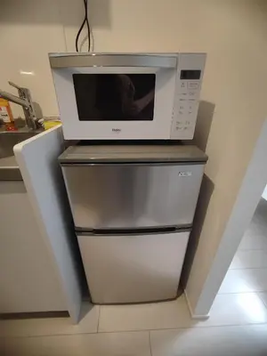 a microwave oven sitting on top of a refrigerator at 102Room,7-minute walk from Uguisudani Station located on the 1nd floor of an apartment-style building Twin room No elevator in Tokyo