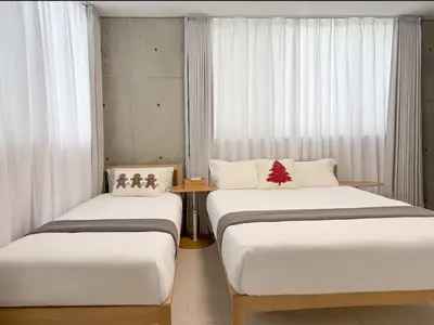 two beds in a room with white curtains at 102Room,7-minute walk from Uguisudani Station located on the 1nd floor of an apartment-style building Twin room No elevator in Tokyo