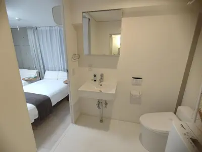 a bathroom with a sink and a toilet and a mirror at 401Room,7-minute walk from Uguisudani Station located on the 4nd floor of an apartment-style building Twin room No elevator in Tokyo