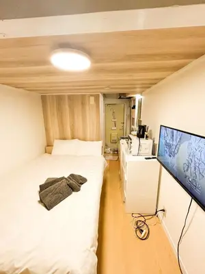 a small room with two beds and a tv at 203 Quiet area walking distance of Shinjuku Shin-Okubo district in Tokyo