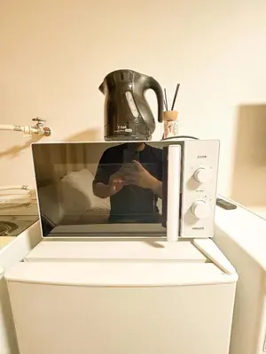 a person taking a picture in a microwave at 203 Quiet area walking distance of Shinjuku Shin-Okubo district in Tokyo