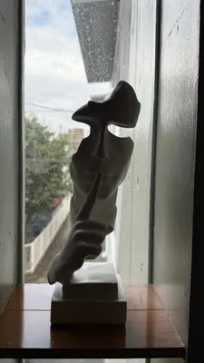 a statue sitting on a table in front of a window at Moon Base Tokyo Inn in Tokyo