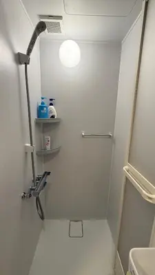 a bathroom with a toilet and a light on the wall at Moon Base Tokyo Inn in Tokyo