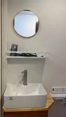a bathroom with a sink and a mirror on the wall at Moon Base Tokyo Inn in Tokyo
