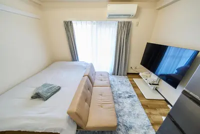 a hotel room with a bed and a flat screen tv at 22\u30e1\u30be\u30f3\u30b8\u30e5\u30cd\u30b9 in Tokyo