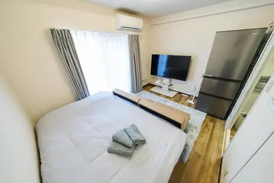 a bedroom with a large bed with a television and a television at 22\u30e1\u30be\u30f3\u30b8\u30e5\u30cd\u30b9 in Tokyo