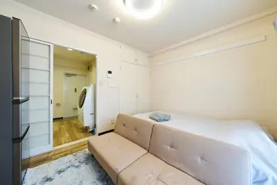 a bedroom with a large bed and a couch at 22\u30e1\u30be\u30f3\u30b8\u30e5\u30cd\u30b9 in Tokyo