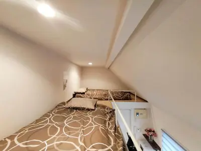 a small bedroom with a bed in a attic at Shinjuku center area-\u65b0\u5927\u4e45\u4fdd\u7ad94\u5206-\u65b0\u5bbf10\u5206-2room-Loft-Max5p-\u76f4\u8fbe\u6d89\u8c37\u4e0a\u91ce\u539f\u5bbf\u94f6\u5ea7 in Tokyo