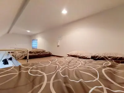 a large room with two beds and a carpet at Shinjuku center area-\u65b0\u5927\u4e45\u4fdd\u7ad94\u5206-\u65b0\u5bbf10\u5206-2room-Loft-Max5p-\u76f4\u8fbe\u6d89\u8c37\u4e0a\u91ce\u539f\u5bbf\u94f6\u5ea7 in Tokyo