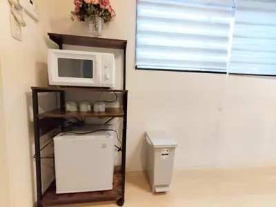 a microwave sitting on a shelf next to a refrigerator at Shinjuku center area-\u65b0\u5927\u4e45\u4fdd\u7ad94\u5206-\u65b0\u5bbf10\u5206-2room-Loft-Max5p-\u76f4\u8fbe\u6d89\u8c37\u4e0a\u91ce\u539f\u5bbf\u94f6\u5ea7 in Tokyo