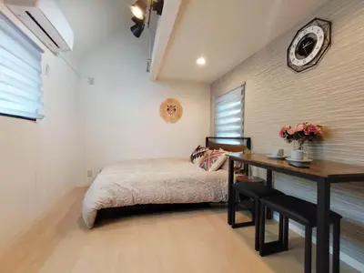 a bedroom with a bed and a table and a clock at Shinjuku center area-\u65b0\u5927\u4e45\u4fdd\u7ad94\u5206-\u65b0\u5bbf10\u5206-2room-Loft-Max5p-\u76f4\u8fbe\u6d89\u8c37\u4e0a\u91ce\u539f\u5bbf\u94f6\u5ea7 in Tokyo