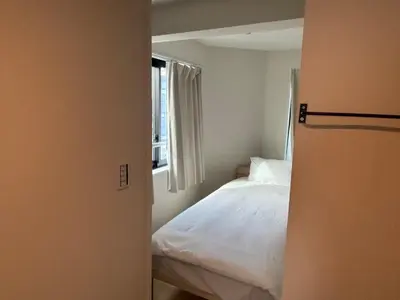 a bedroom with a white bed and a window at \u3055\u304f\u3089\u65c5\u9928\u9ad8\u5186\u5bfa\u5317\u5343\u5229\u4f11302\u53f7\u5ba4 in Tokyo