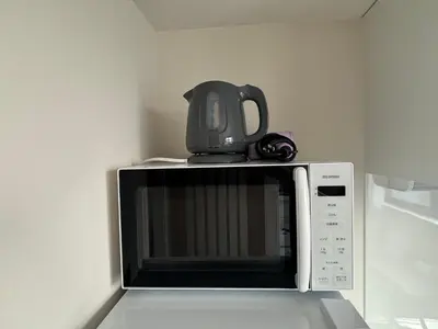 a microwave with a tea kettle on top of it at \u3055\u304f\u3089\u65c5\u9928\u9ad8\u5186\u5bfa\u5317\u5343\u5229\u4f11302\u53f7\u5ba4 in Tokyo