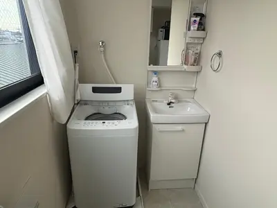 a small bathroom with a washing machine and a sink at \u3055\u304f\u3089\u65c5\u9928\u9ad8\u5186\u5bfa\u5317\u5343\u5229\u4f11302\u53f7\u5ba4 in Tokyo