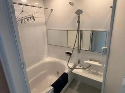 a white bathroom with a tub and a mirror at \u3055\u304f\u3089\u65c5\u9928 \u9ad8\u5186\u5bfa\u5317\u5343\u5229\u4f11 301\u53f7\u5ba4 in Tokyo